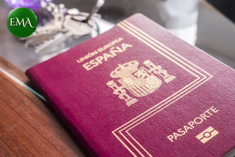 Pasaporte español junto a unas llaves: renovar la residencia antes de jurar la nacionalidad