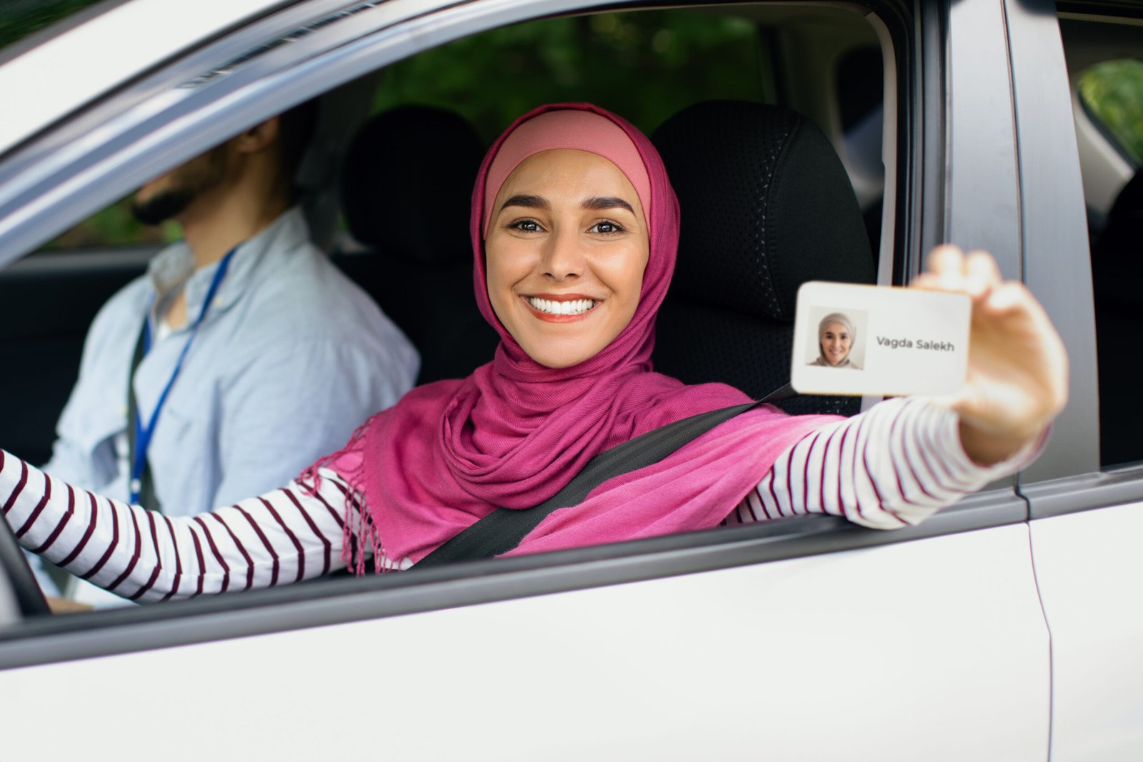 Mujer sonriente mostrando su carnet de conducir marroquí desde un coche