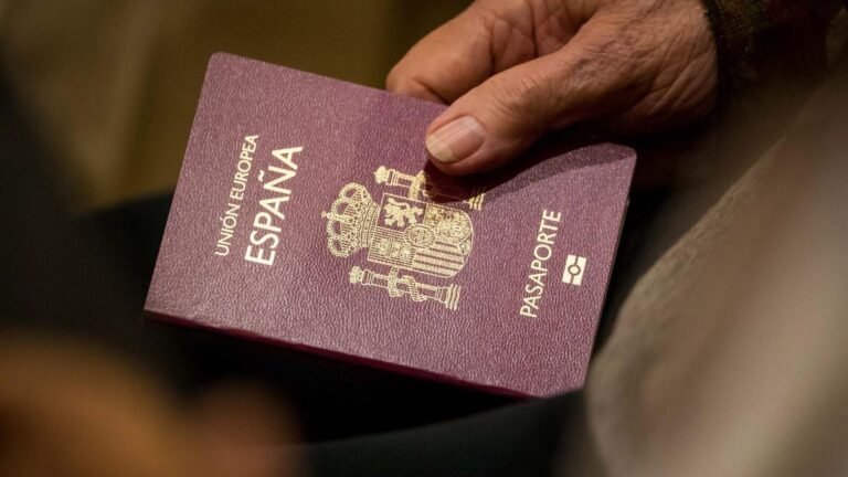 Mano sosteniendo un pasaporte español en primer plano - solicitar la nacionalidad española por residencia
